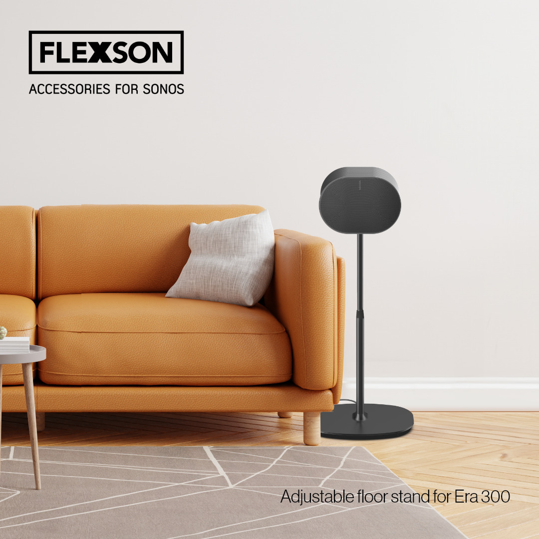 Neben einer braunen Couch steht ein Bodenständer mit einem Sonos Lautsprecher Era300.